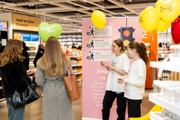 Zwei IKEA-Mitarbeiterinnen erklären Besucherinnen das Ampelsystem bei einem Event im Einrichtungshaus.

