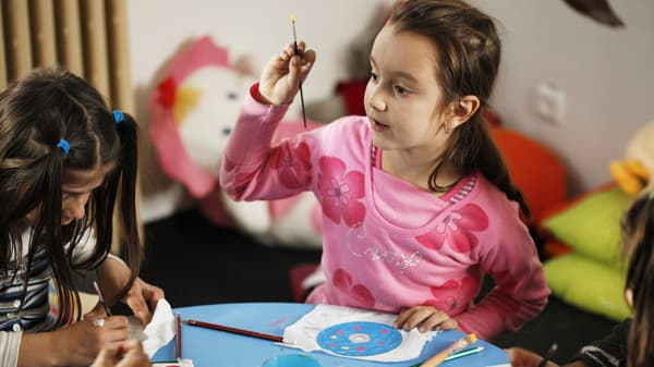 Zwei kleine Mädchen nehmen an einem Bastelworkshop teil