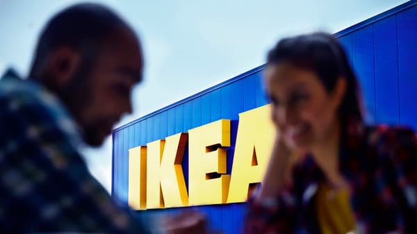 Zwei Personen sitzen vor einem IKEA Einrichtungshaus.