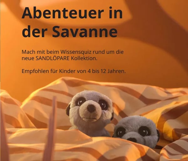 Zwei Sandmänchen auf einer Bettdecke und dem Text Abenteuer in der Savanne.