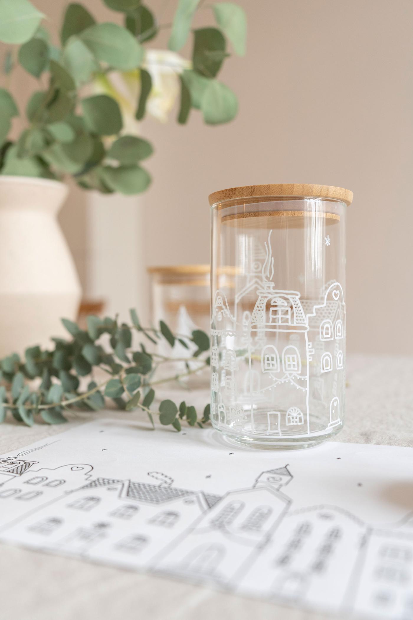 Zwei selbstbemalte Vorratsgläser EKLATANT leer auf einem gedeckten Tisch. 