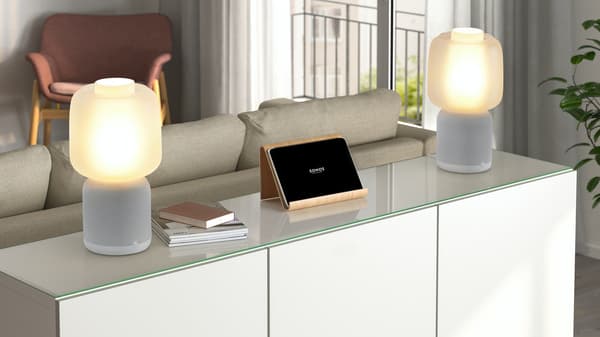 Zwei SYMFONSIK Lautsprecher stehen in einem Wohnzimmer auf einem weißen Tisch.