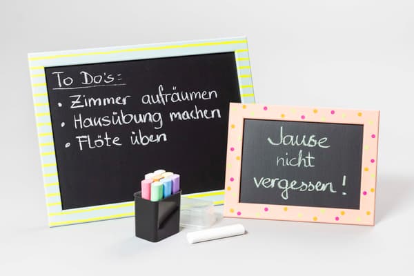 Zwei verzierte Bilderrahmen mit Tafelfolie. Auf den Bilderrahmen stehen Notizen.