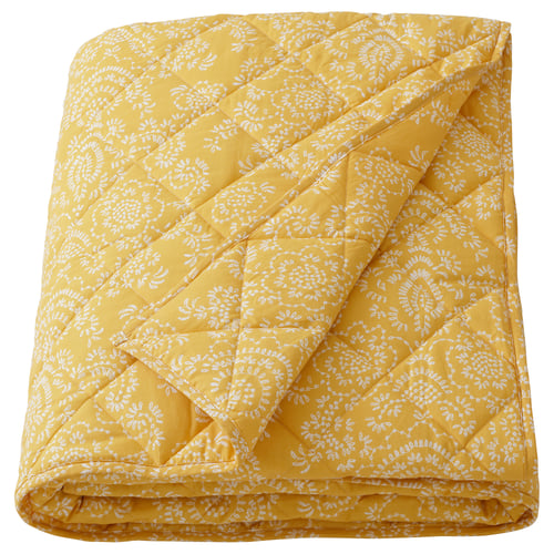 Yellow yellow quilted blanket with white floral pattern, soft cotton and polyester, folded square.