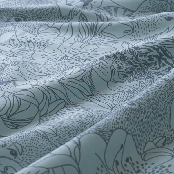 Close-up of fairytale-themed bedding with detailed animal and floral prints.