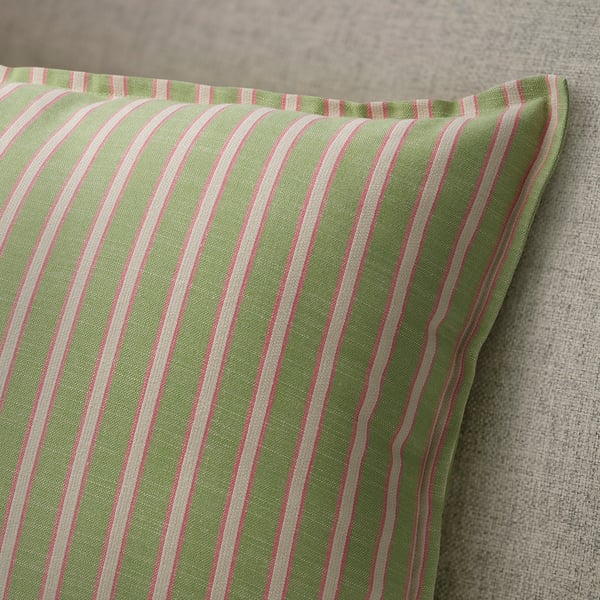 A close-up of a striped green and pink cushion cover, showcasing its high-quality cotton texture and neatly sewn edges with a hidden zip.
