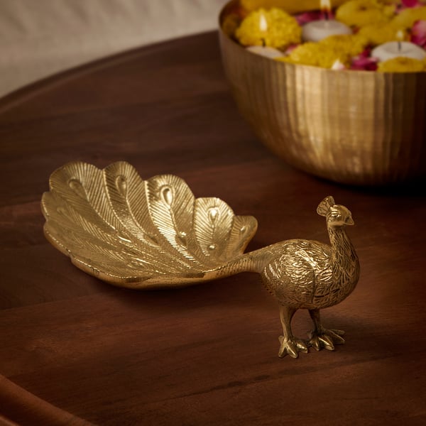 Gold peacock decor with acrylic-coated aluminium on wood, smaller than nearby bowl, feathered for holding potpourri.