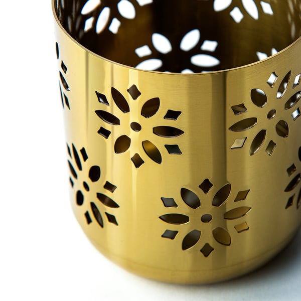 Gold-colored cylindrical candle holder with intricate floral cutouts, reflecting high-quality craftsmanship and metallic finish.