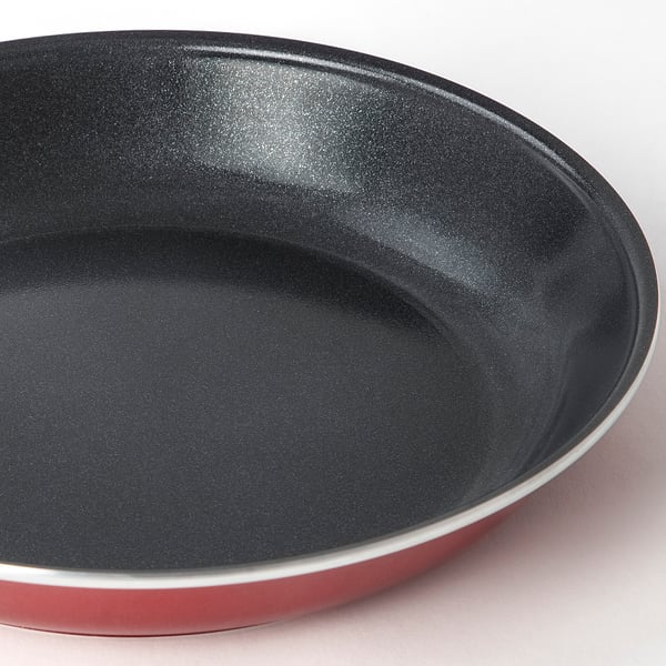 Black and red non-stick frying pan, shown from above, highlighting smooth surface and sleek design.