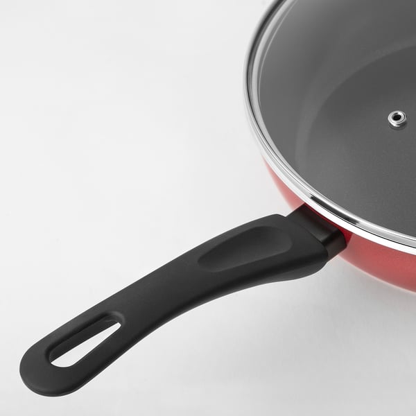 Image depicts a red sauté pan with a black handle and lid, showcasing its non-stick interior and sturdy, ergonomic design.