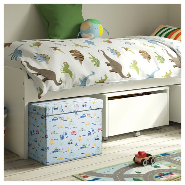 Kids dinosaur-themed white bed with green toy.