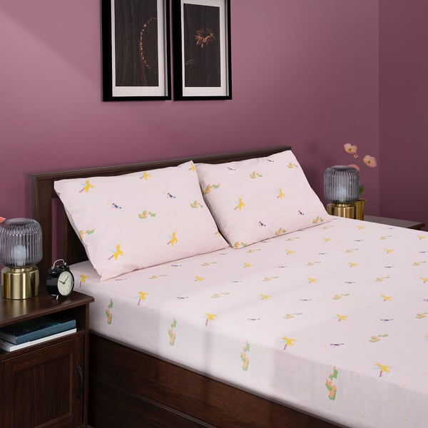 Bed with unicorn duvet, cotton blend, purple wall, bedside lamp, clock, vase.