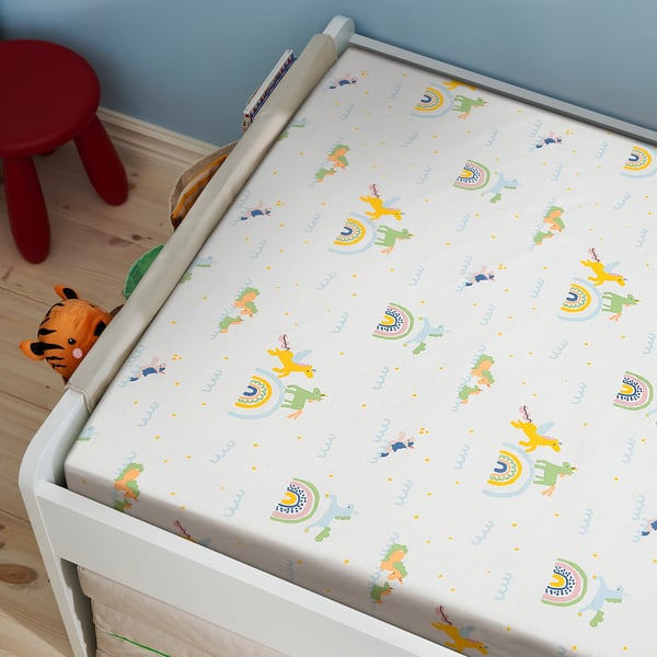 A childs bed with a white mattress cover featuring a colourful unicorn and rainbow pattern. The mattress appears cosy and designed for comfort.