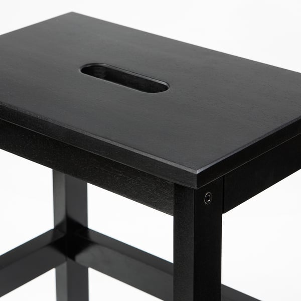 Black wooden step stool with hand hole, sturdy and stylish design.