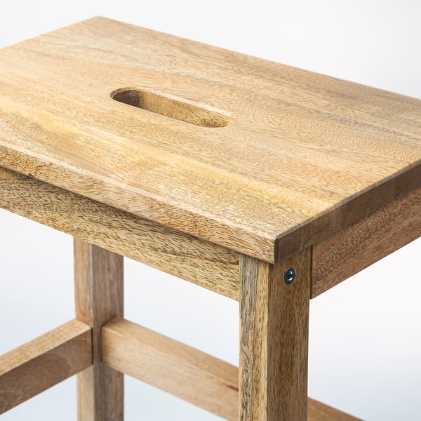 Solid wood step stool with smooth, polished finish. Has a hand-hole for easy movement. Made from mango wood with a natural grain design.