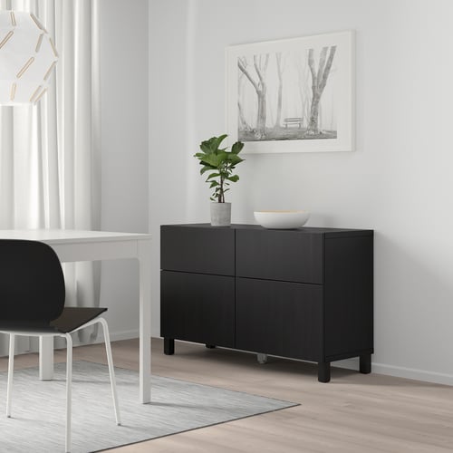 Black BESTÅ unit with plant, bowl, near table, chair, under tree print.