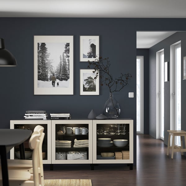 Modern dark dining room with BESTÅ sideboard, photos, and decor.