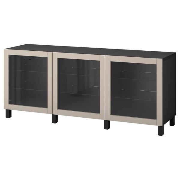 An ikea BESTÅ sideboard with three glass doors, black and beige in color. It adjustable shelves and soft-closing hinges.