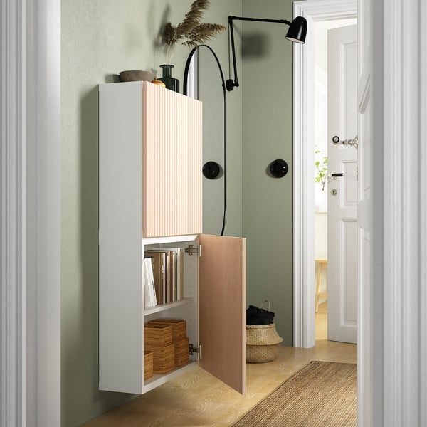 Modern storage cabinet with wall-mounted design, offering adjustable shelves inside and soft-close hinges. One door open, revealing organised items.
