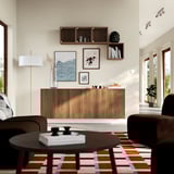 Modern living space with BESTÅ wooden storage unit against wall, featuring adjustable shelves, decorative art, and cosy seating.