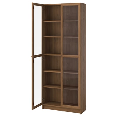 A BILLY bookcase with glass doors, brown colour, wooden material, rectangular shape, and sleek design.