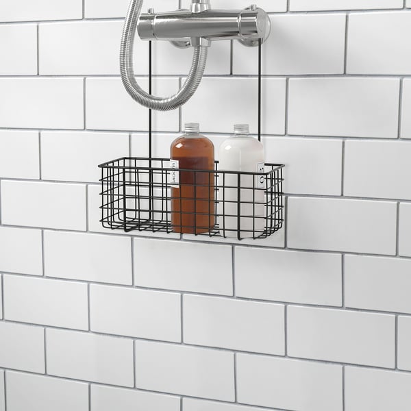 A metal wire basket holding two bottles, mounted on a tiled wall in a bathroom, providing convenient storage for shower items.