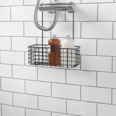A metal wire basket holding two bottles, mounted on a tiled wall in a bathroom, providing convenient storage for shower items.