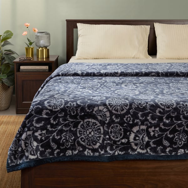 Blue-grey floral blanket on bed, recycled polyester.