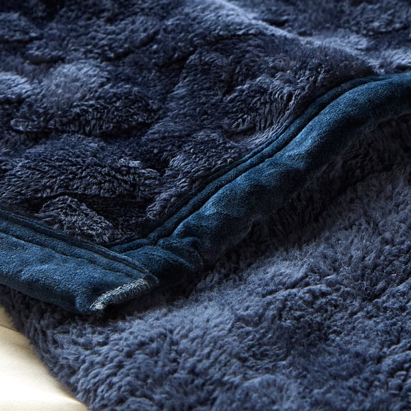 Close-up of luxurious, thick, navy blue fleece blanket showcasing its soft texture and sleek stitching.