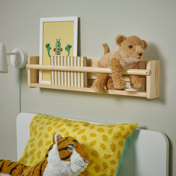 Wall shelf above bed with teddy bear and 1, 2, 3 poster, yellow pillows.