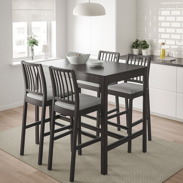Elegant modern black ash dining set with four chairs and table. Perfect for small spaces, set on a patterned rug near a window.