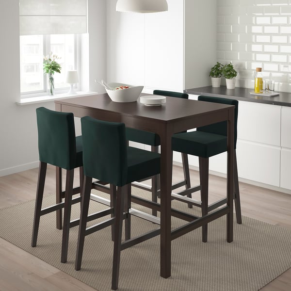 Dark brown bar table with 4 green stools, footrest, in bright kitchen.