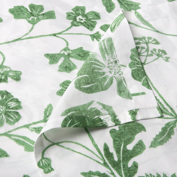 Green leaf pattern on a crisp white cloth. High-quality fabric, fresh, natural design.