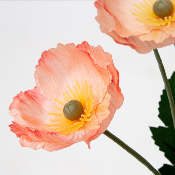 Vibrant orange & yellow artificial flowers on white background.