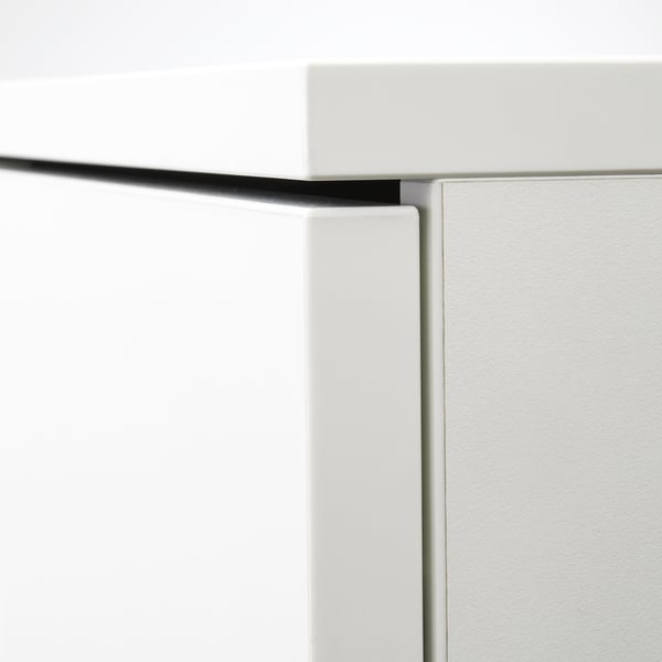 Close-up of white cabinet corner, showing clean, modern design with sleek edges and neat finish.