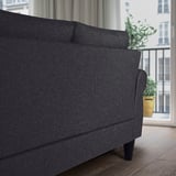 Dark grey sofa by window, cushions for comfort, durable design.