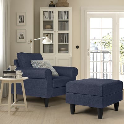 Cosy blue armchair & ottoman; white side table; glass-door bookcase.