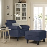 A GAMMALBYN blue armchair and footstool, dark legs, white bookcase, side table with cup and books.