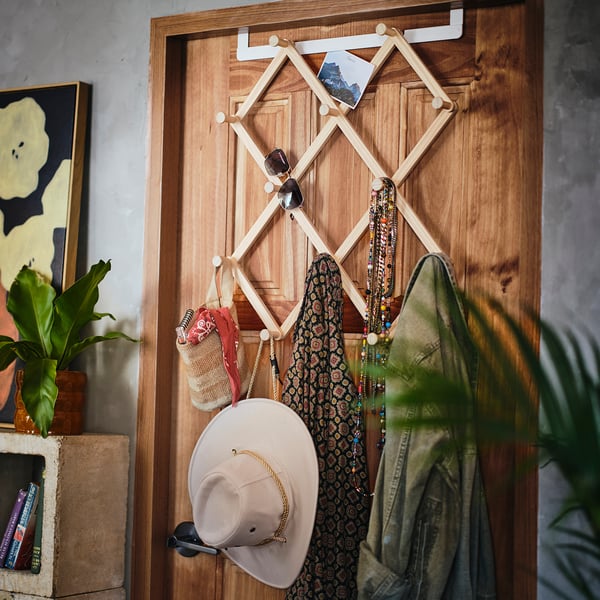 Kompishang door organiser with 24 hooks, holding hat, scarf, and sunglasses, mounted on door, maximises space efficiently.
