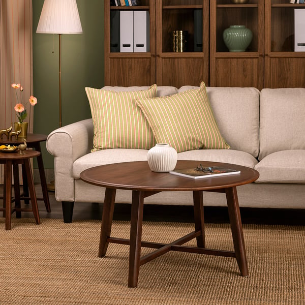 KRAGSTA brown coffee table, round & wooden, fits well beside beige sofa.
