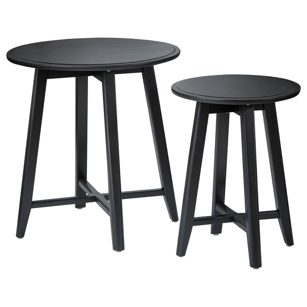 Two black round nesting tables with sleek legs and smooth tops, made from solid mango wood, stylish and functional.