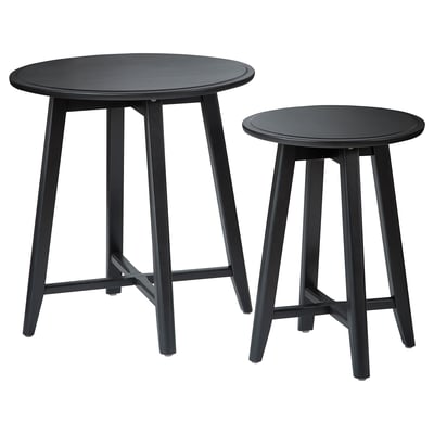 Two black round nesting tables with sleek legs and smooth tops, made from solid mango wood, stylish and functional.