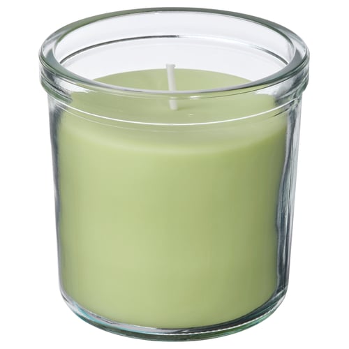 LÖVSKOGSLUND green apple scented candle in clear glass jar, cylindrical with white wick.