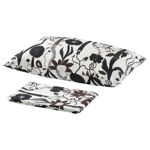 A set of white bedding with black floral patterns. It includes a flat sheet and pillowcases, showcasing an elegant, monochromatic design.