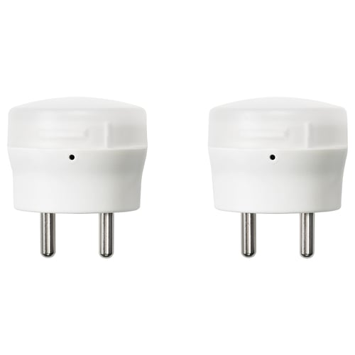 Two white, cylindrical nightlights with metal pins at the bottom, positioned side by side.