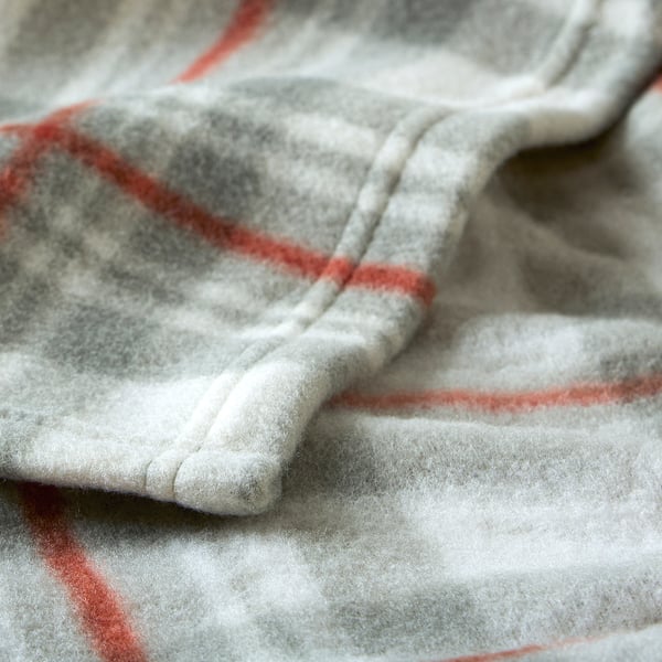 Folded soft blanket with red and grey check pattern, showcasing its smooth and cosy texture.