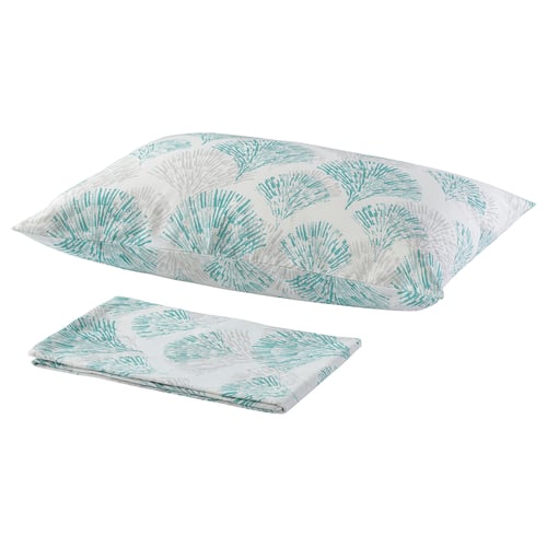 Two turquoise and white floral pillows with a fan-like pattern lay flat, one folded.