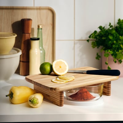 SNEDNÄBB bamboo cutting board, rectangular, with lemon slices, lime, pepper, and spices.