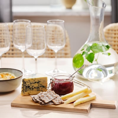 SNEDNÄBB bamboo cutting board, rectangular, natural colour. Holds cheese, crackers, and jam. Smaller than wine glasses, larger than a coaster.