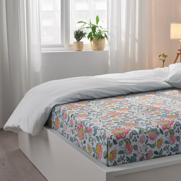 Floral bedsheet set with 2 pillowcases, lit by natural light.